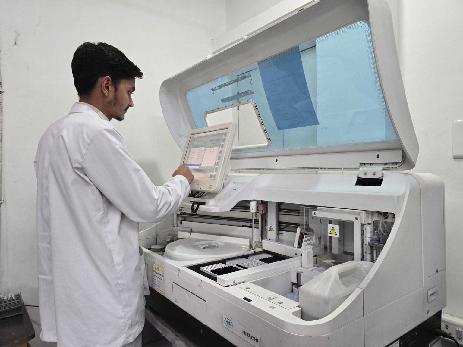 Technician operating an advanced diagnostic analyzer at the best pathology lab in Udaipur, Arth Diagnostics, showcasing modern equipment and reliable testing services